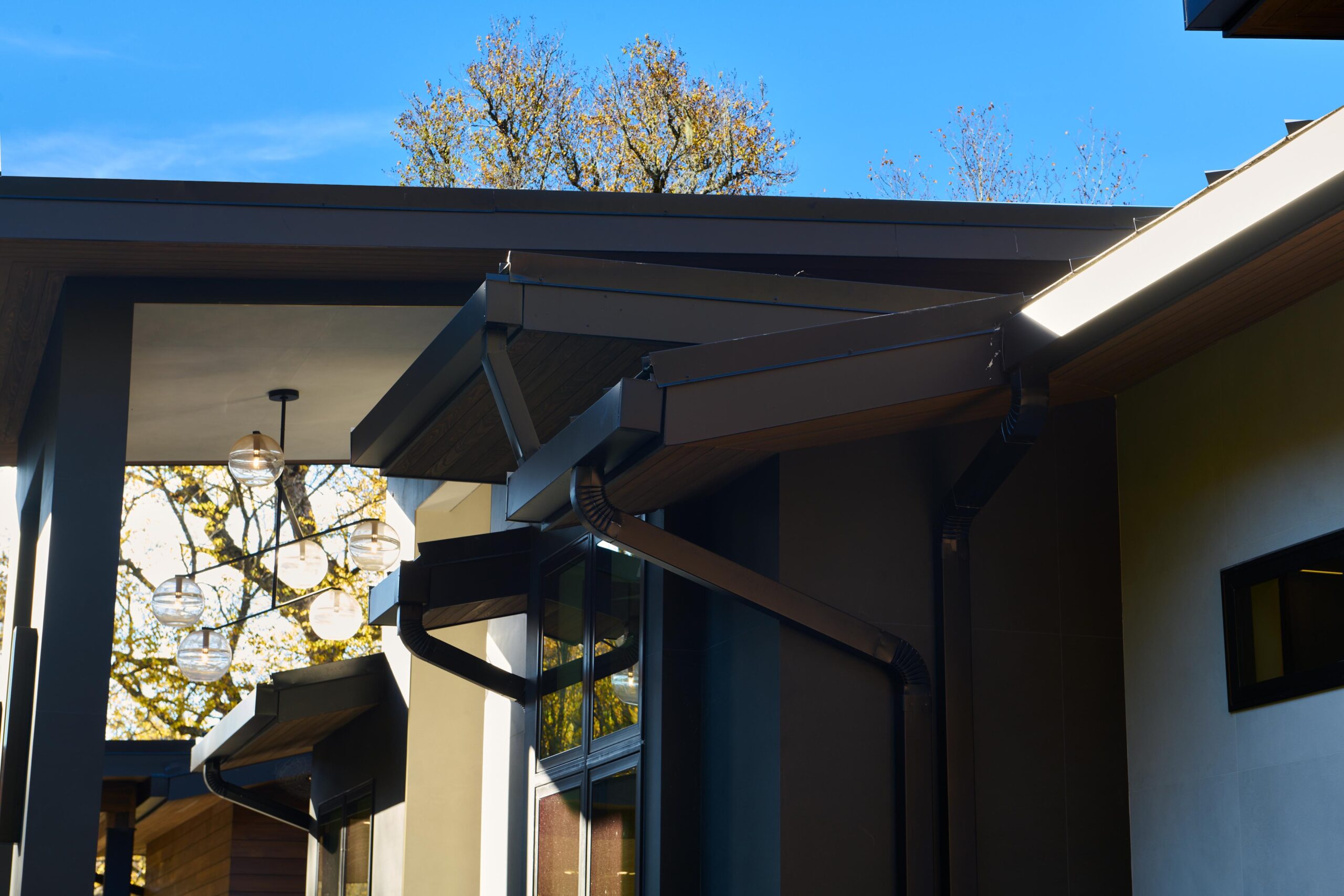 a_house_with_a_patio_and_a_large_tree_brdb_highlands_nc_porch_natural_light